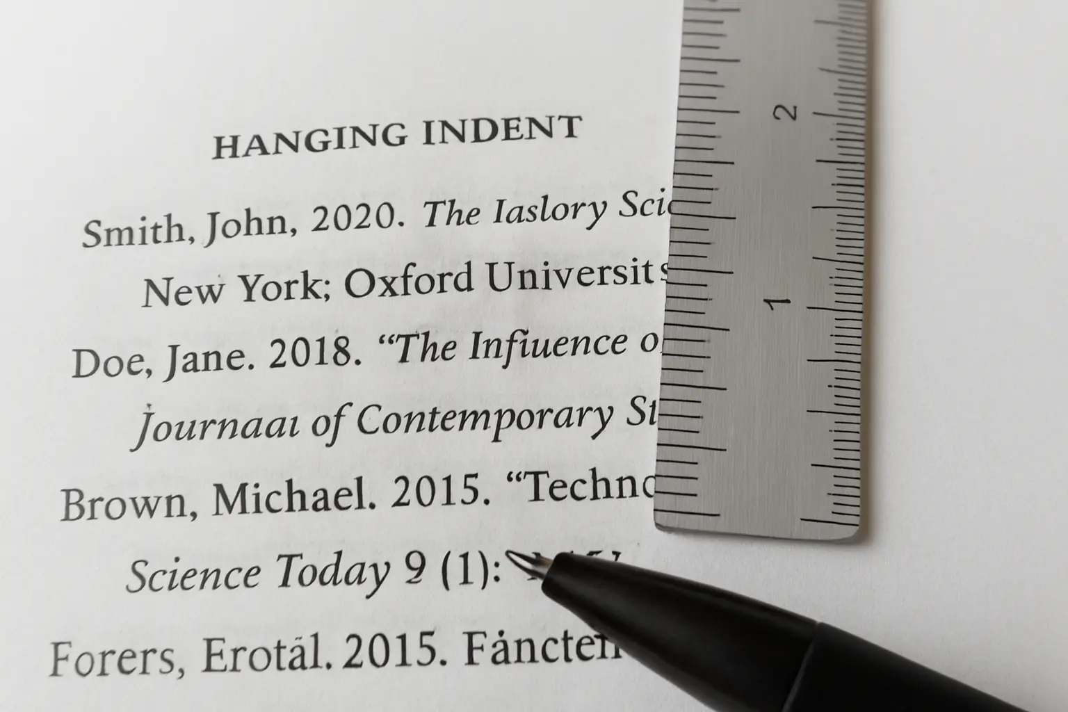 A printed APA reference page showing hanging indents with a ruler measuring the indent
