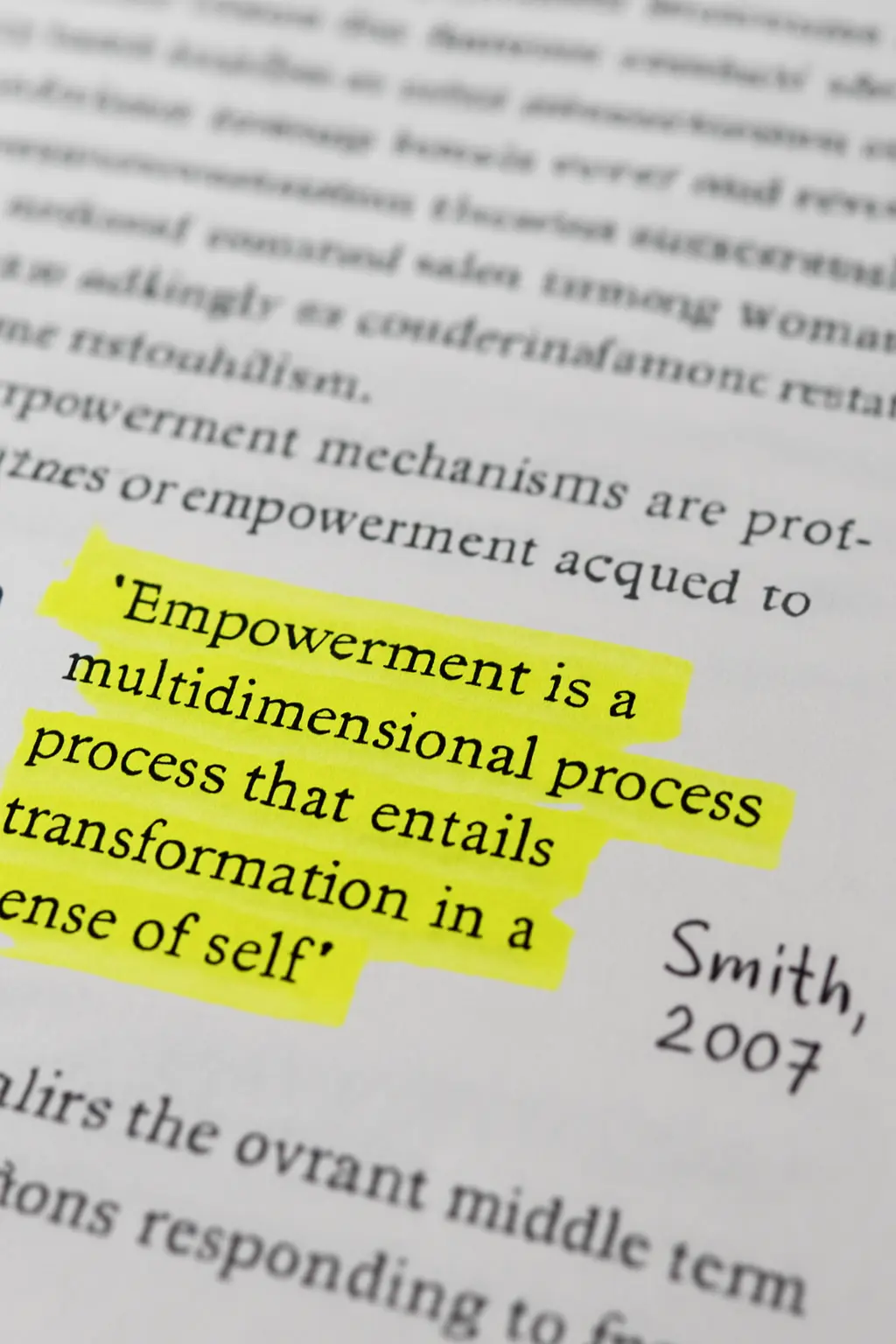 A highlighted quotation in a printed thesis paragraph with its citation written in the margin