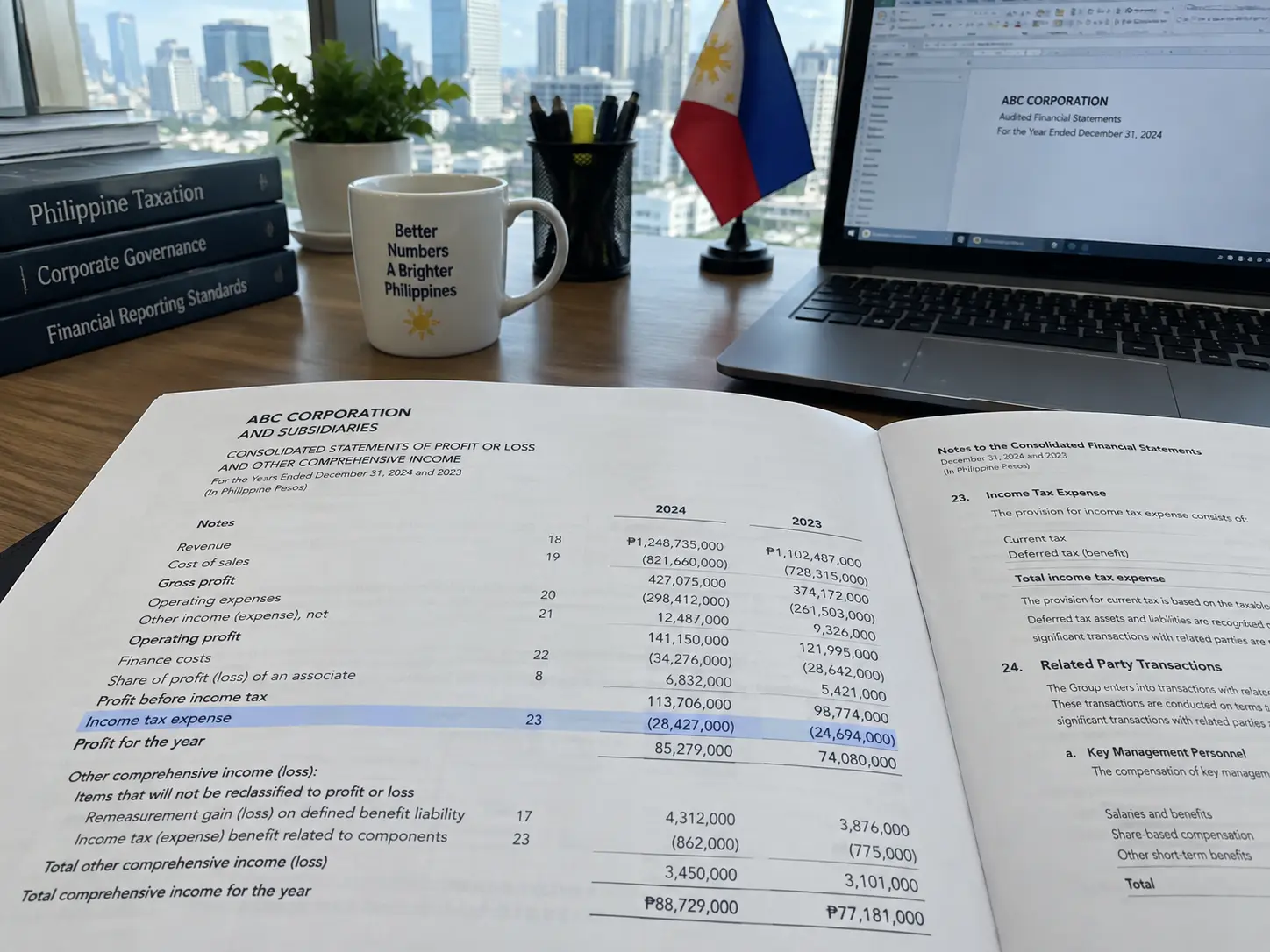 A printed audited financial statement showing an income tax expense line item on an office desk