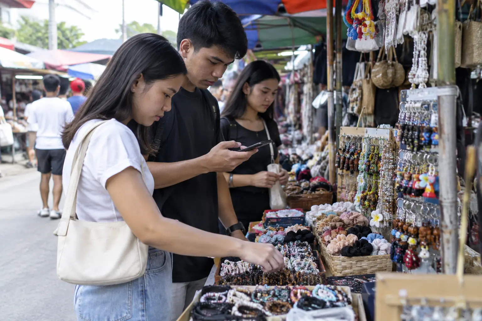 Filipino shoppers at a market stall checking a phone before buying
